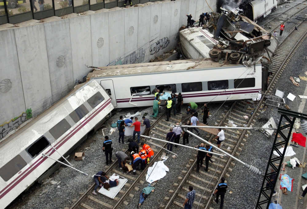 Rescuers tend to victims next to derailed cars at the site of a train accident near the city of Santiago de Compostela on July 24, 2013. Photo by Oscar CORRAL / AFP