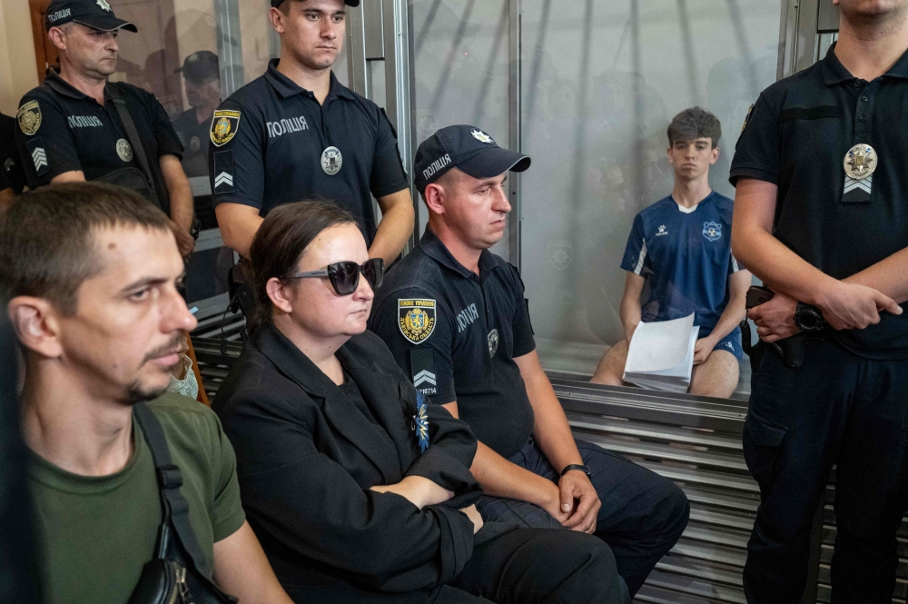 Vyacheslav Zinchenko, 18, suspected of killing Iryna Farion, a prominent former nationalist lawmaker and professor at the Lviv's Institute of the Humanities and Social Sciences, stands in a prisoner's box as he attends his hearing at the Lviv court in Lviv, on July 26, 2024. (Photo by Ivan STANISLAVSKY / AFP)

