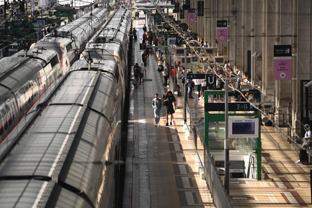 Passengers walk on train platform at the Bordeaux-Saint-Jean train station in Bordeaux, western France on July 26, 2024. (Photo by Christophe Archambault / AFP)