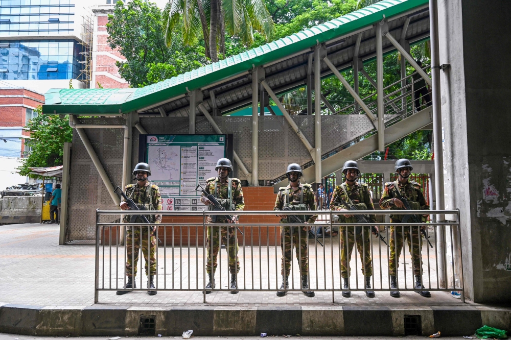 Bangladesh army stand guard at a metro station as the curfew is relaxed after the anti-quota protests, in Dhaka on July 27, 2024. (Photo by Munir Uz Zaman / AFP)