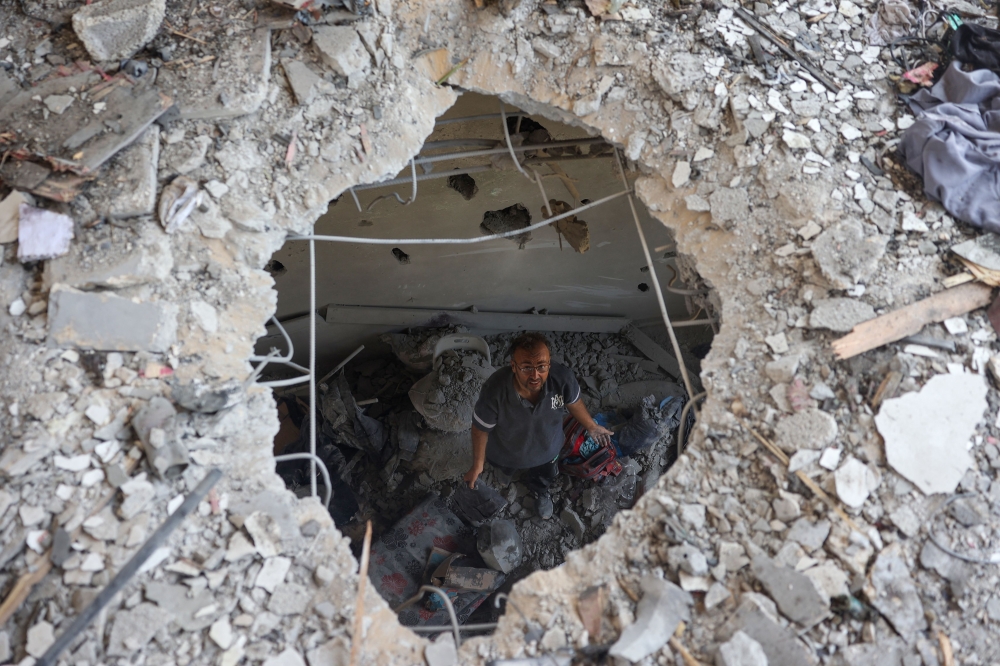 A Palestinian man inspects the damage following an Israeli strike on the Khadija school housing displaced people in Deir al-Balah, in the central Gaza Strip on July 27, 2024.(Photo by Eyad Baba / AFP)
