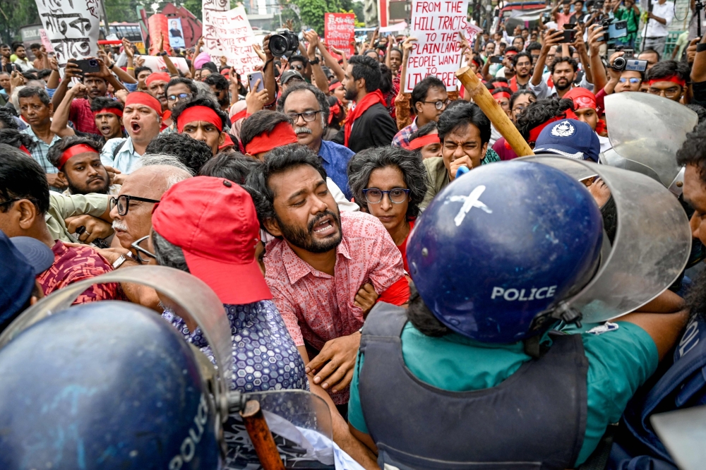 Cultural activists and members of civil society clash with police personnel during a song march for victims who were killed during the recent nationwide student protests in Dhaka on July 30, 2024. (Photo by Munir Uz Zaman / AFP)
