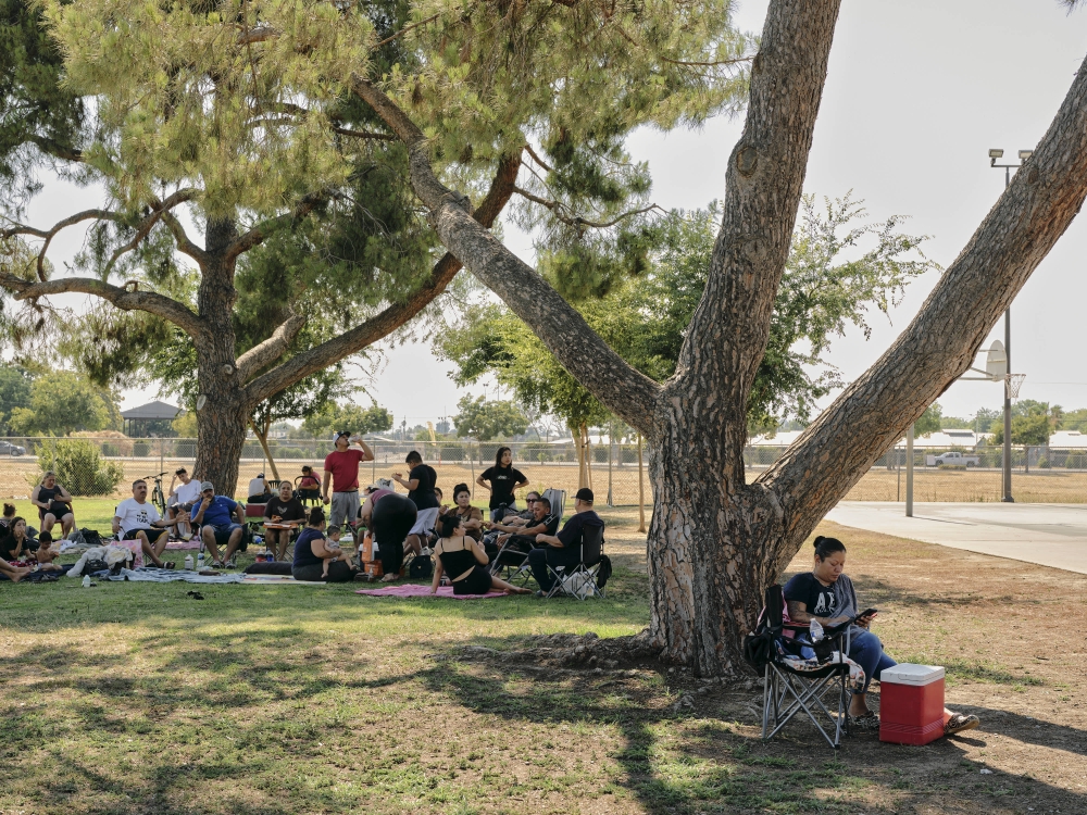 People sit in the shade at Mosqueda Park in Fresno, California as temperatures soar into the triple digits. (Photo by Philip Cheung for The Washington Post)

