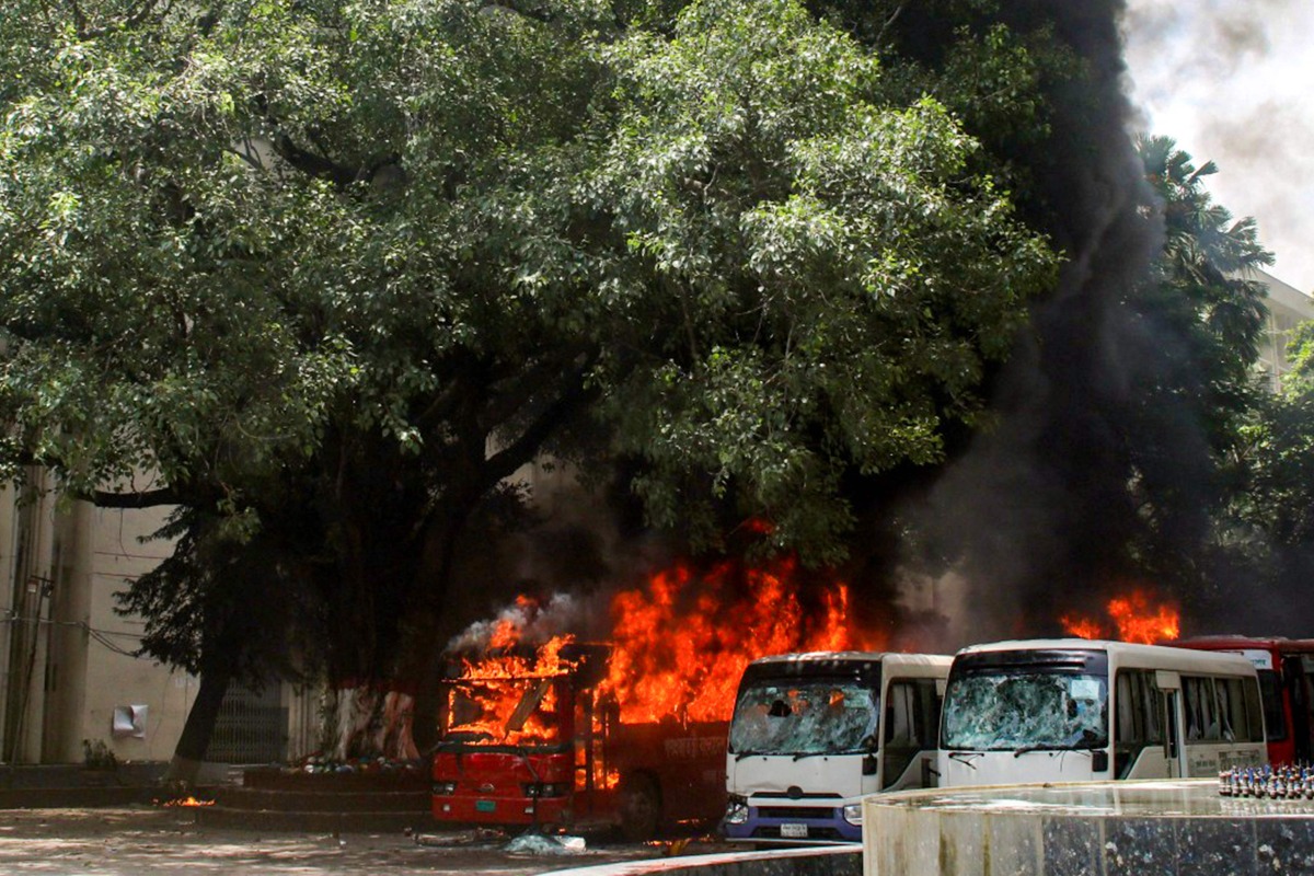 Buses are seen on fire at the Bangabandhu Sheikh Mujib Medical University premises after a clash between students and government supporters during a protest in Dhaka on August 4, 2024. (Photo by Abdul GONI / AFP)
