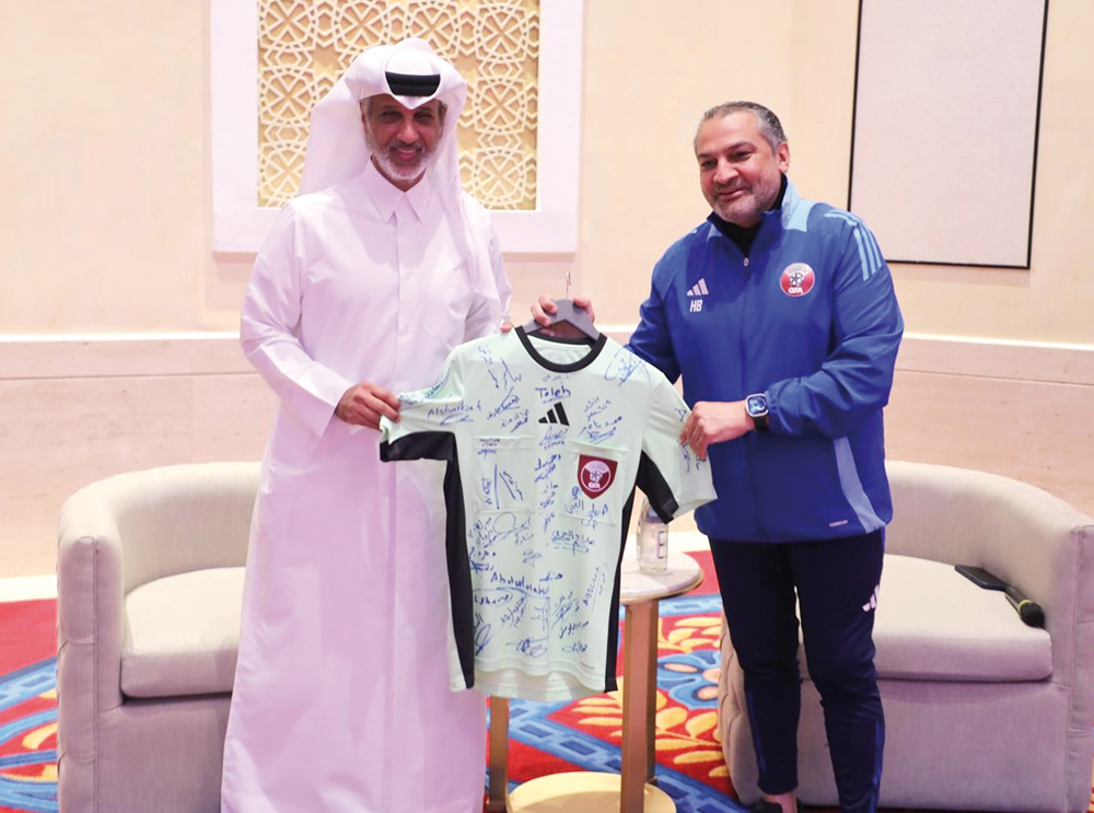 Minister of Sports and Youth H E Sheikh Hamad bin Khalifa bin Ahmed Al Thani receives a jersey from Chairman of the QFA’s Referees Committee Hani Taleb Ballan.  