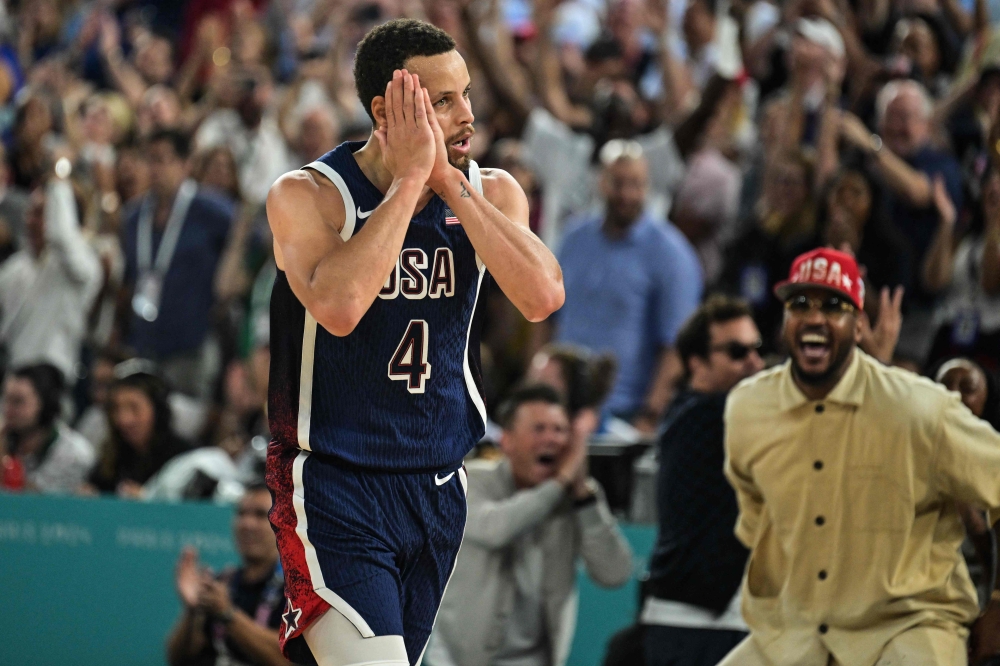 USA's #04 Stephen Curry celebrates scoring a three-point field goal in the men's Gold Medal basketball match between France and USA during the Paris 2024 Olympic Games at the Bercy Arena in Paris on August 10, 2024. (Photo by Damien MEYER / AFP)

