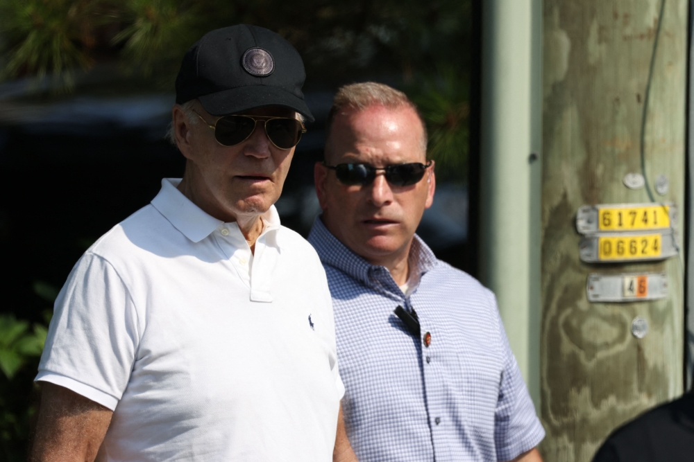 US President Joe Biden (L) departs the beach on August 10, 2024, in Rehoboth Beach, Delaware. (Photo by SAMUEL CORUM / AFP)

