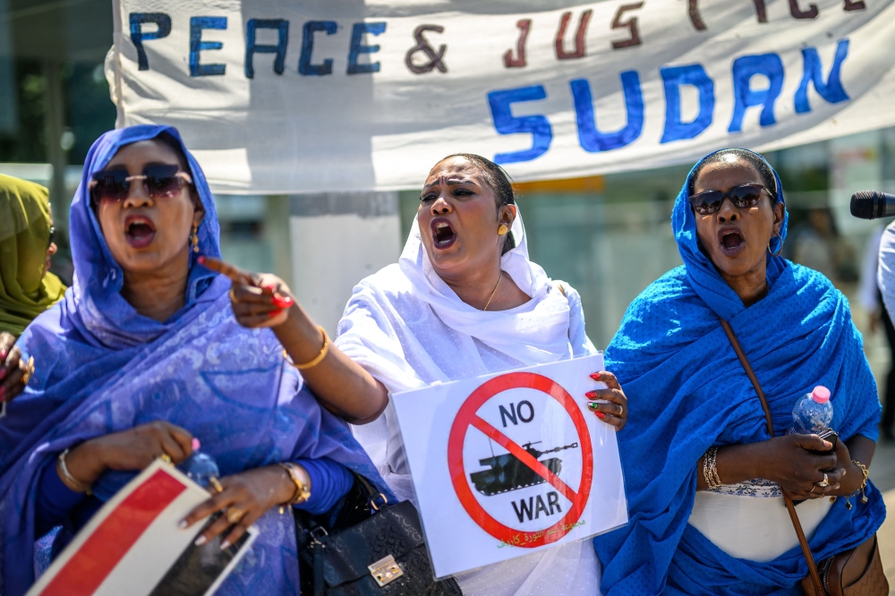 Women shout slogans as they take part to a demonstration on the opening day of Sudan ceasefire talks, in Geneva, on August 14, 2024. US-sponsored talks on agreeing a ceasefire in the devastating conflict in Sudan kicked off in Switzerland, despite the Sudanese government staying away. (Photo by Fabrice COFFRINI / AFP)
