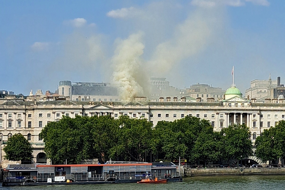 Viewed from Waterloo Bridge, smoke is seen rising into the sky from a fire located in the roof of Somerset House beside the River Thames in London on August 17, 2024. Photo by James RYBACKI / AFP
