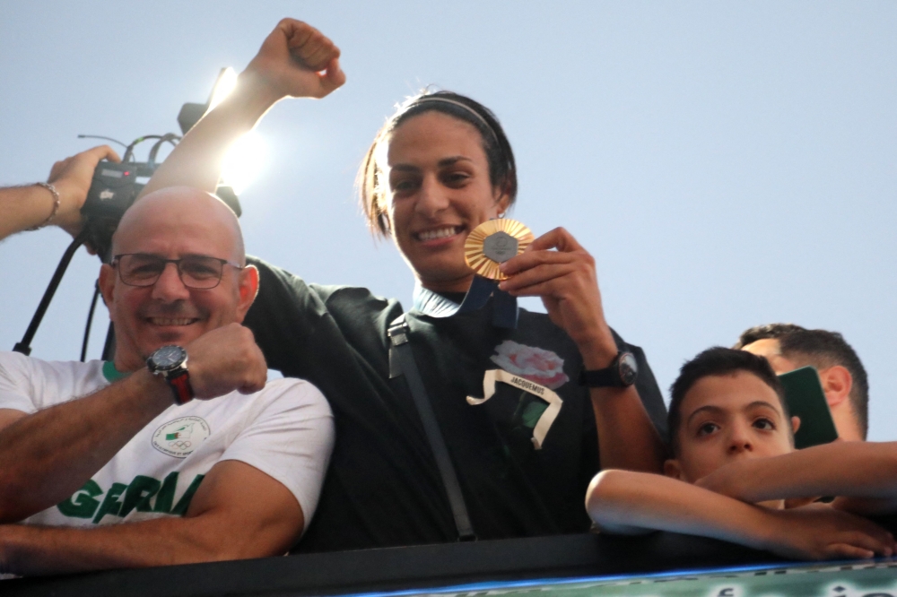 Algerian gold medallist Imane Khelif greets crowds during a bus tour in her hometown city of Tiaret on August 16, 2024. (Photo by AFP)