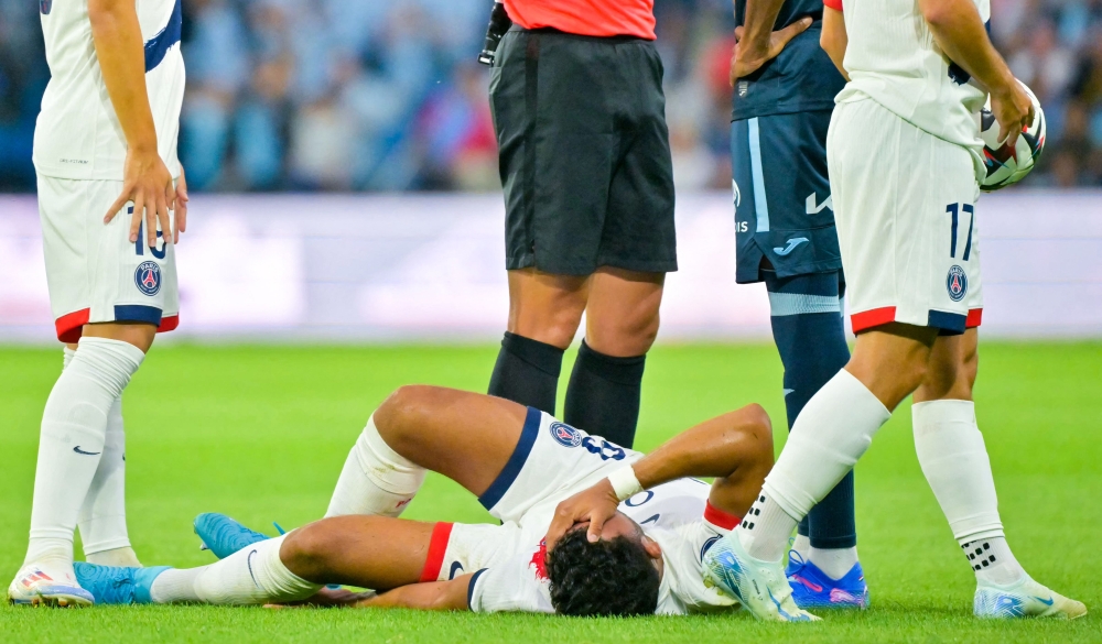 Paris Saint-Germain's Portuguese forward #09 Goncalo Ramos (C) reacts as he lies on the pitch after being injured during the French L1 football match between Le Havre AC and Paris Saint-Germain (PSG) at The Stade Oceane in Le Havre, north-western France on August 16, 2024. (Photo by LOU BENOIST / AFP)
