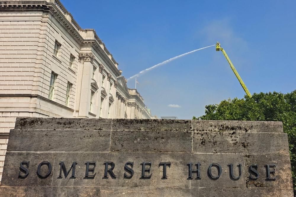 Firefighters direct water onto the roof of Somerset House after smoke from a fire was seen coming from the roof earlier in the afternoon, beside the River Thames in London on August 17, 2024. (Photo by James RYBACKI / AFP)
