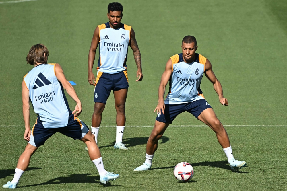 (From L) Real Madrid's Croatian midfielder #10 Luka Modric, Real Madrid's Brazilian forward #11 Rodrygo and Real Madrid's French forward #10 Kylian Mbappe attend a training session with teammates at the training ground of Valdebebas on the eve of their Liga football match against RCD Mallorca, in Madrid on August 17, 2024. (Photo by JAVIER SORIANO / AFP)
