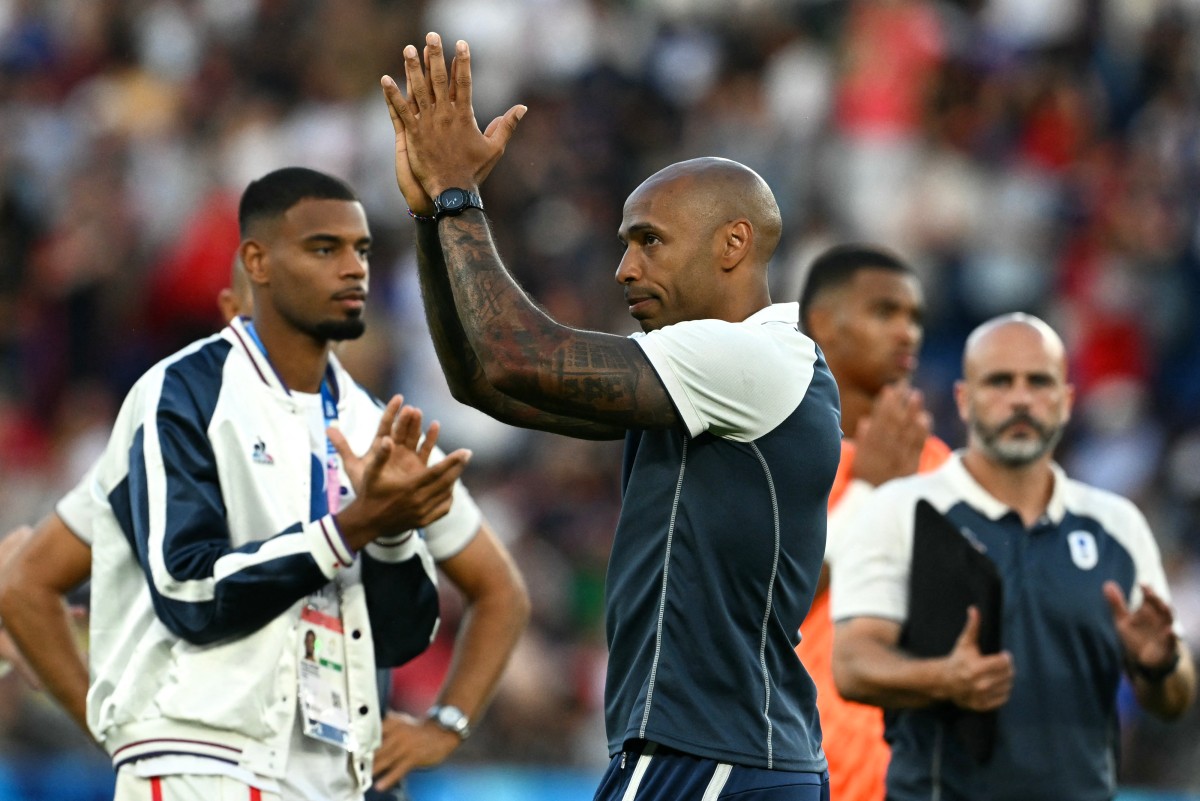 France's coach Thierry Henry acknowledges the fans at the end of the men's gold medal final football match between France and Spain during the Paris 2024 Olympic Games at the Parc des Princes in Paris on August 9, 2024. (Photo by PATRICIA DE MELO MOREIRA / AFP)
