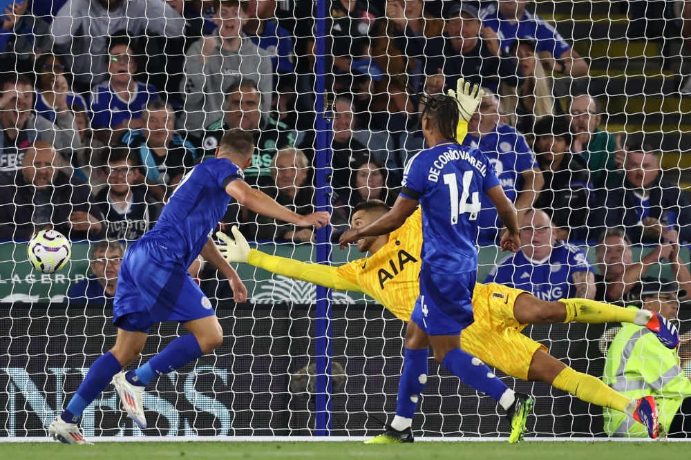 Leicester City's English striker #09 Jamie Vardy (L) heads the ball past Tottenham Hotspur's Italian goalkeeper #01 Guglielmo Vicario for their first goal during the English Premier League football match between Leicester City and Tottenham Forest at King Power Stadium in Leicester, central England on August 19, 2024. (Photo by Darren Staples / AFP)