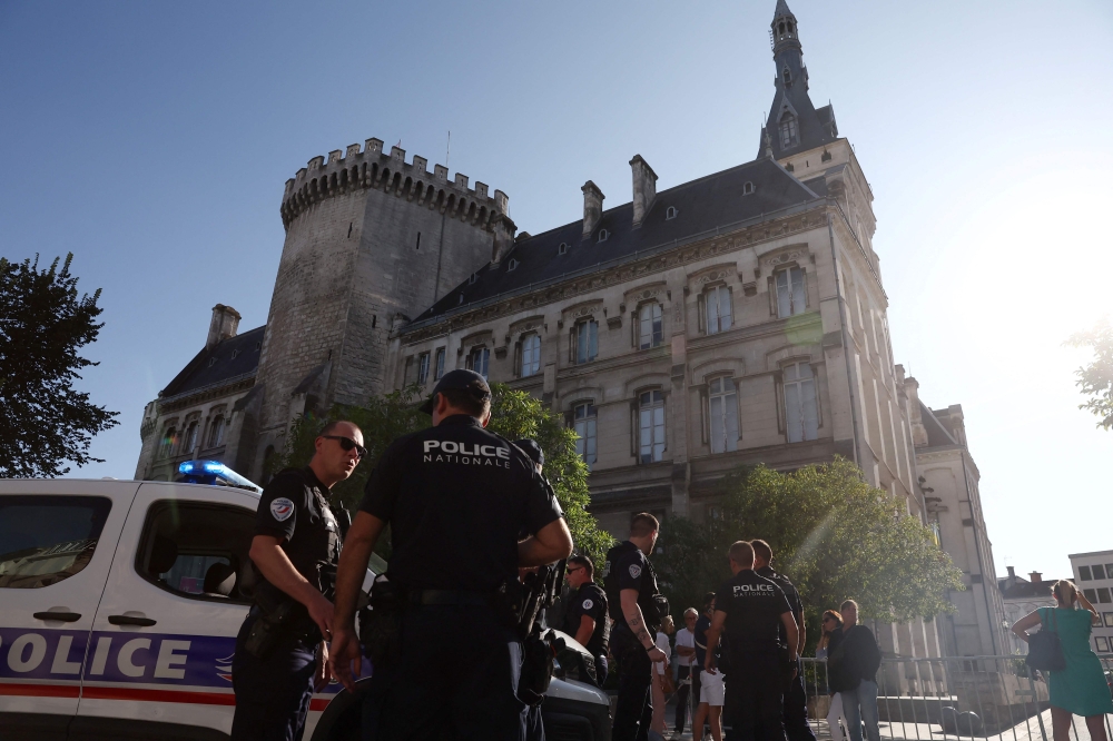French police stand guard in front of the Town Hall after a man attempted to set the building alight with petrol in Angouleme on August 21, 2024. (Photo by Romain PERROCHEAU / AFP)
