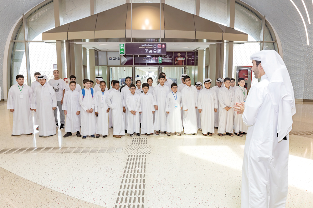 A Qatar Rail official briefs students at a metro station. 
