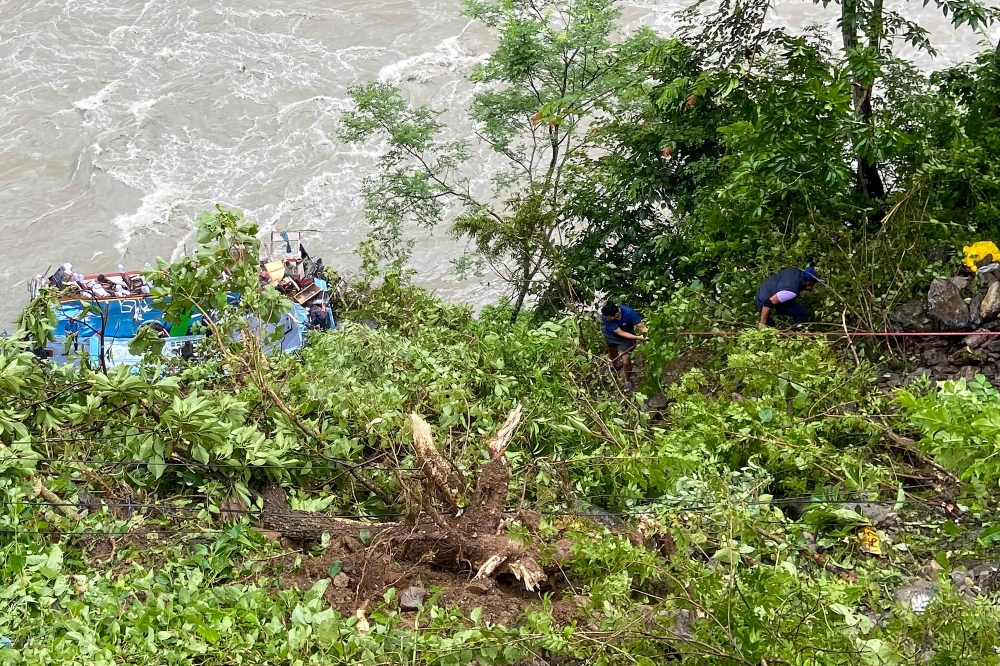Rescue personnel gather at the site after a bus carrying Indian passengers plunged into the Marsyangdi river in Nepal's Tanahun district on August 23, 2024. (Photo by SHANKHAR ADHIKARI / AFP)
