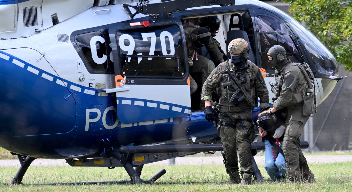 Members of a special police unit escort a man suspected to be responsible for the Solingen knife attack from a helicopter to the office of the Federal Prosecutor in Karlsruhe, southern Germany, on August 25, 2024.