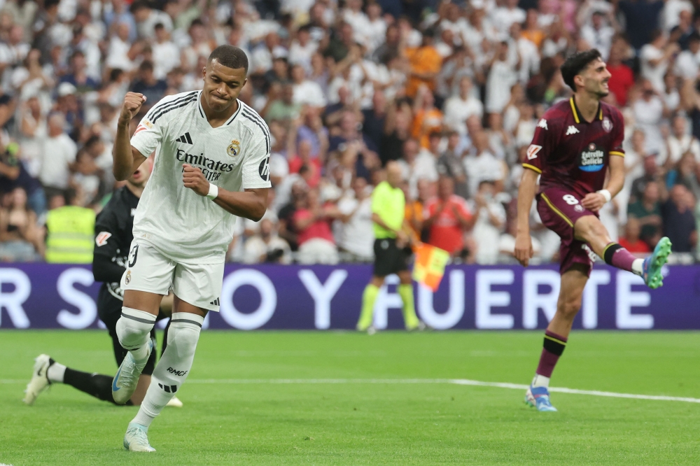 Real Madrid's French forward #09 Kylian Mbappe celebrates the opening goal, scored by Real Madrid's Uruguayan midfielder #08 Federico Valverde, during the Spanish league football match between Real Madrid CF and Real Valladolid FC at the Santiago Bernabeu stadium in Madrid on August 25, 2024. (Photo by Pierre-Philippe MARCOU / AFP)
