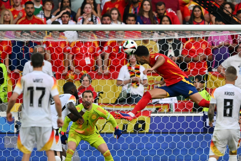 Spain's midfielder #06 Mikel Merino (CR) heads the ball and scores his team's second goal during the UEFA Euro 2024 quarter-final football match between Spain and Germany at the Stuttgart Arena in Stuttgart on July 5, 2024. (Photo by Fabrice COFFRINI / AFP)

