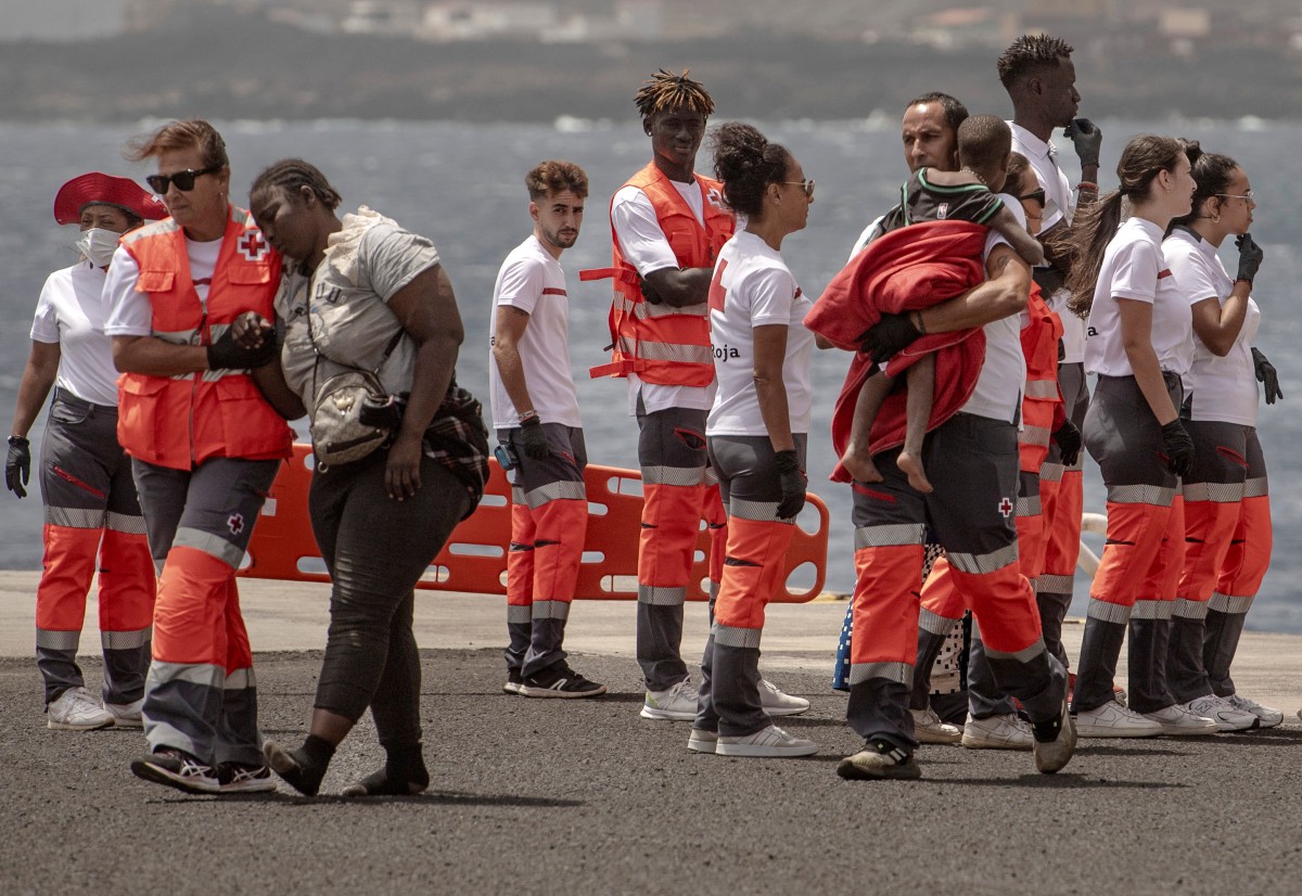 Members of the emergency services help a woman and a little child, part of a group of 136 African migrant people, upon their arrival at La Restinga port aboard the Spanish Salvamento Maritimo (Sea Search and Rescue agency) vessel 