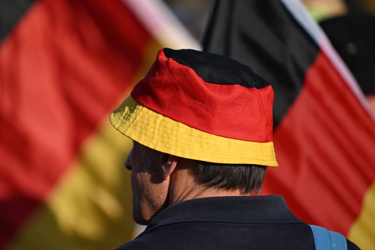 A supporter wears a hat in the colors of the German national flag on August 29, 2024 in the historic center of Dresden, eastern Germany during a campaign event of the far-right Alternative for Germany party (AfD) for the upcoming Saxony state elections. Photo by RALF HIRSCHBERGER / AFP.