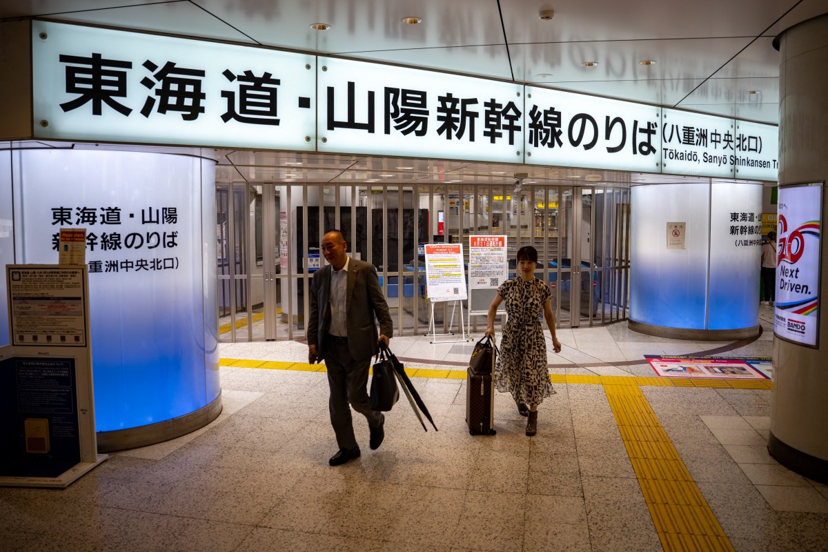 People walk in front of closed ticket gates for the Tokaido Shinkansen as train operations between Tokyo and Nagoya are suspended, in Tokyo Station, due to Typhoon Shanshan crawling across Japan on August 31, 2024. (Photo by Philip FONG / AFP)
