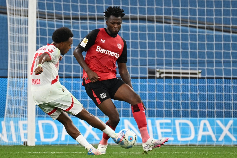 Leipzig's Belgian forward #11 Lois Openda scores the 2-3 goal past Bayer Leverkusen's Burkinabe defender #12 Edmond Tapsoba during the German first division Bundesliga football match between Bayer 04 Leverkusen and RB Leipzig in Leverkusen, southwestern Germany on August 31, 2024. (Photo by UWE KRAFT / AFP)
