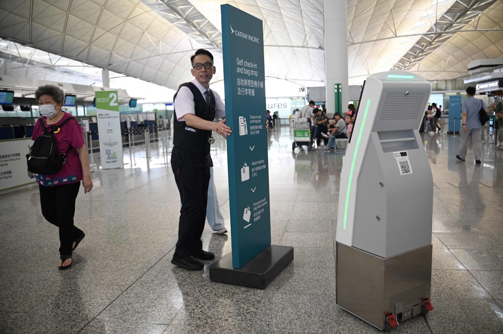 A Cathay Pacific employee moves a sign board at the international airport in Hong Kong on September 4, 2024. Photo by Peter PARKS / AFP