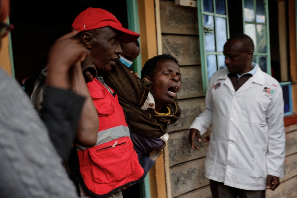 A woman reacts after visiting the burned dorm room at the Nyeri county's Hillside Endarasha Academy in Nyeri county on September 6, 2024. (Photo by Simon Maina / AFP)