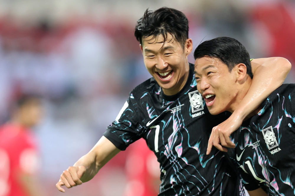 South Korea's forward and captain #07 Son Heung-min celebrates with his striker #11 Hwang Hee-chan after the latter scored a goal during the 2026 FIFA World Cup Asian qualification football match between Oman and South Korea in Muscat on September 10, 2024. (Photo by Haitham AL-SHUKAIRI / AFP)