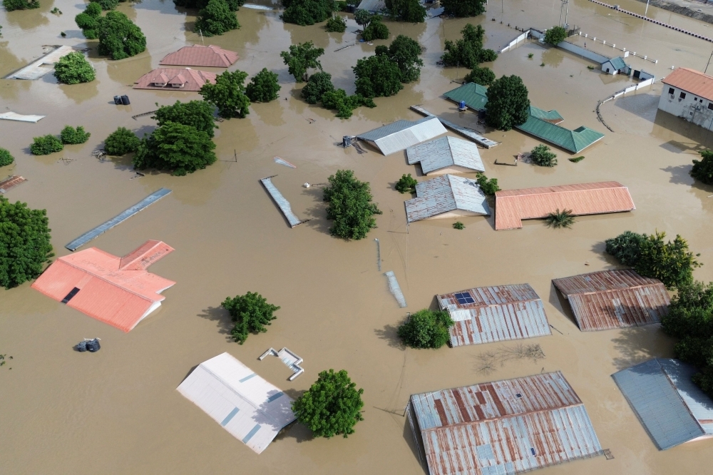 This aerial view shows houses submerged under water in Maiduguri on September 10, 2024. (Photo by Audu Marte / AFP)

