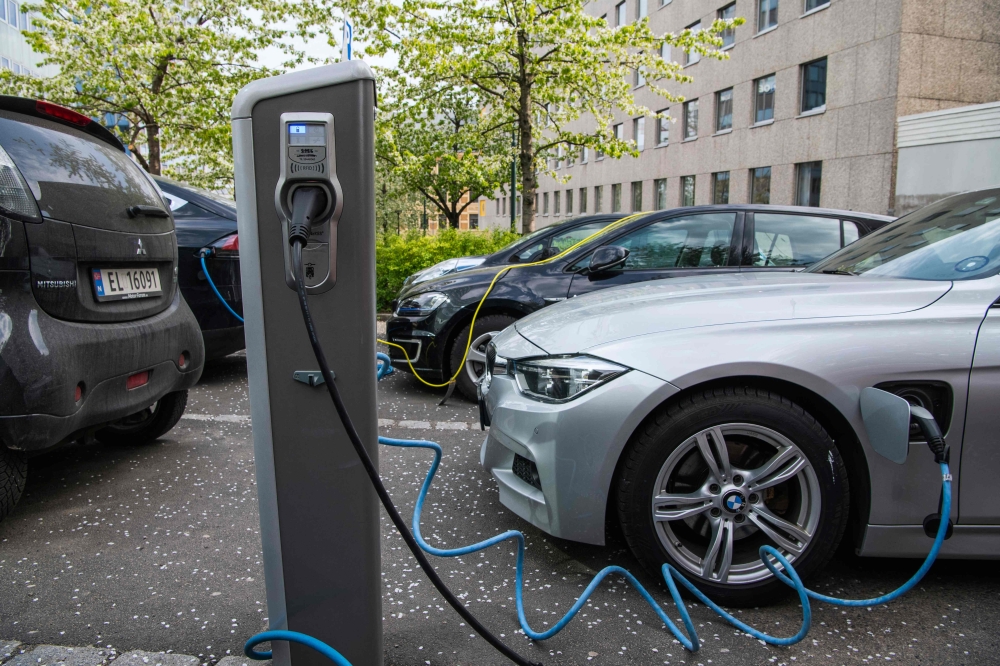 File: Electric cars are being charged on a street in the Norwegian capital Oslo on April 30, 2019. (Photo by Jonathan Nackstrand / AFP)


