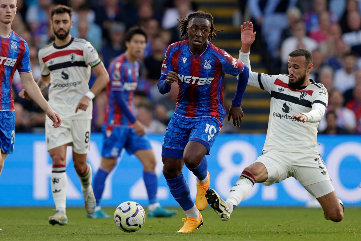 Crystal Palace's English midfielder #10 Eberechi Eze (C) runs away from Manchester United's Moroccan defender #03 Noussair Mazraoui (R) during the English Premier League football match between Crystal Palace and Manchester United at Selhurst Park in south London on September 21, 2024. (Photo by Ian Kington / AFP) 