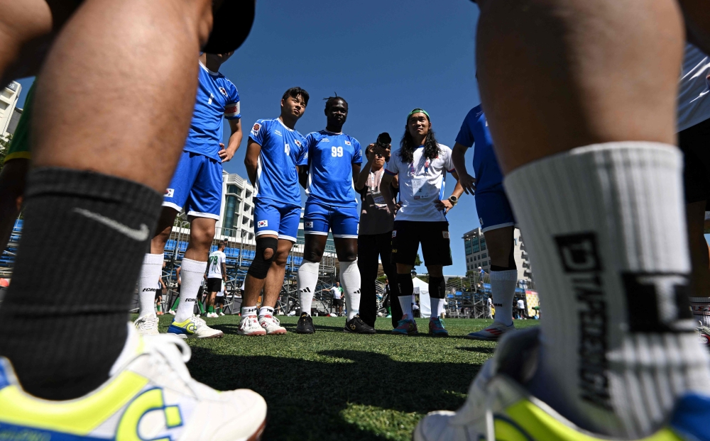 Cameroon refugee Fossi Wandji (C, #99) and his South Korean teammates gather before the men's group stage 4x4 football match between South Korea and Switzerland at the 2024 Homeless World Cup in Seoul on September 24, 2024. Photo by Jung Yeon-je / AFP