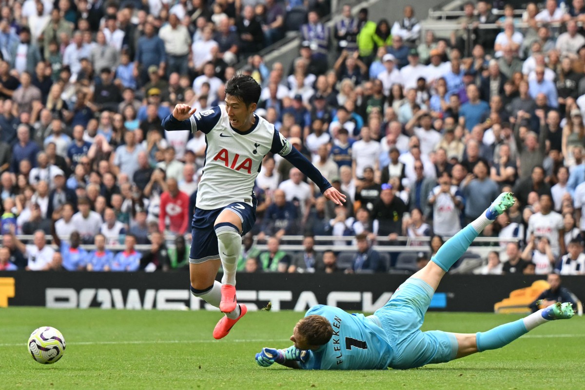 Tottenham Hotspur's South Korean striker #07 Son Heung-Min (L) tries to take the ball around Brentford's Dutch goalkeeper #01 Mark Flekken (R) during the English Premier League football match between Tottenham Hotspur and Brentford at the Tottenham Hotspur Stadium in London, on September 21, 2024. (Photo by Glyn KIRK / AFP)