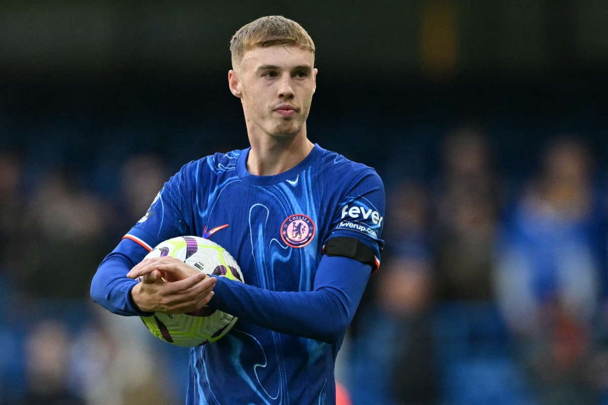 Chelsea's English midfielder #20 Cole Palmer walks off with the match ball having score all four goals in the English Premier League football match between Chelsea and Brighton and Hove Albion at Stamford Bridge in London on September 28, 2024. Chelsea won the game 4-2. Photo by Glyn KIRK / AFP.