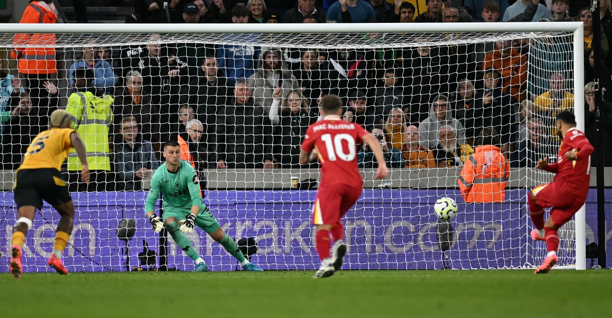 Liverpool's Egyptian striker #11 Mohamed Salah scores the team's second goal from the penalty spot during the English Premier League football match between Wolverhampton Wanderers and Liverpool at the Molineux stadium in Wolverhampton, central England on September 28, 2024. (Photo by Paul ELLIS / AFP) 