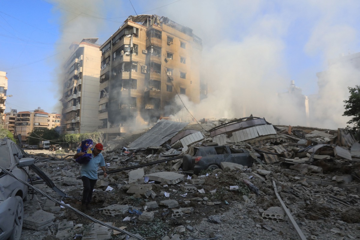 A man walks through the rubble as people check on September 28, 2024 the devastation in the Hadath neighbourhood of Beirut's southern suburbs in the aftermath of overnight Israeli airstrikes on the outskirts of the Lebanese capital. (Photo by AFP)
