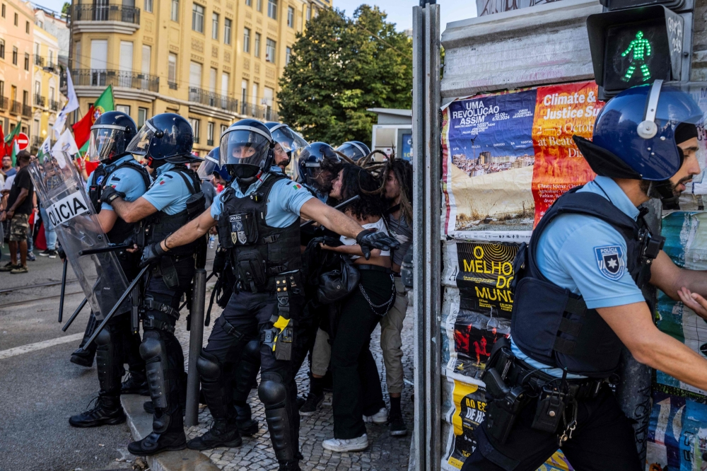Portuguese police detain a woman who was protesting against the demonstration against 
