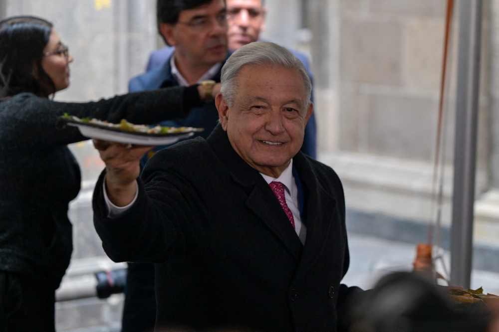 Outgoing Mexican President Andres Manuel Lopez Obrador offers breakfast to journalists in attendance after delivering his last daily conference at the National Palace in Mexico City on September 30, 2024.  (Photo by Alfredo Estrella / AFP)