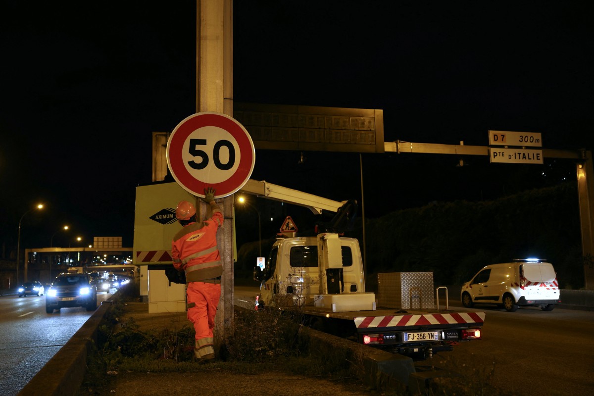 Construction workers install a 50km/h speed limit sign on Paris' ring road, the boulevard peripherique, at the Porte d'Ivry in Paris, on September 30, 2024. Photo by Thomas SAMSON / AFP