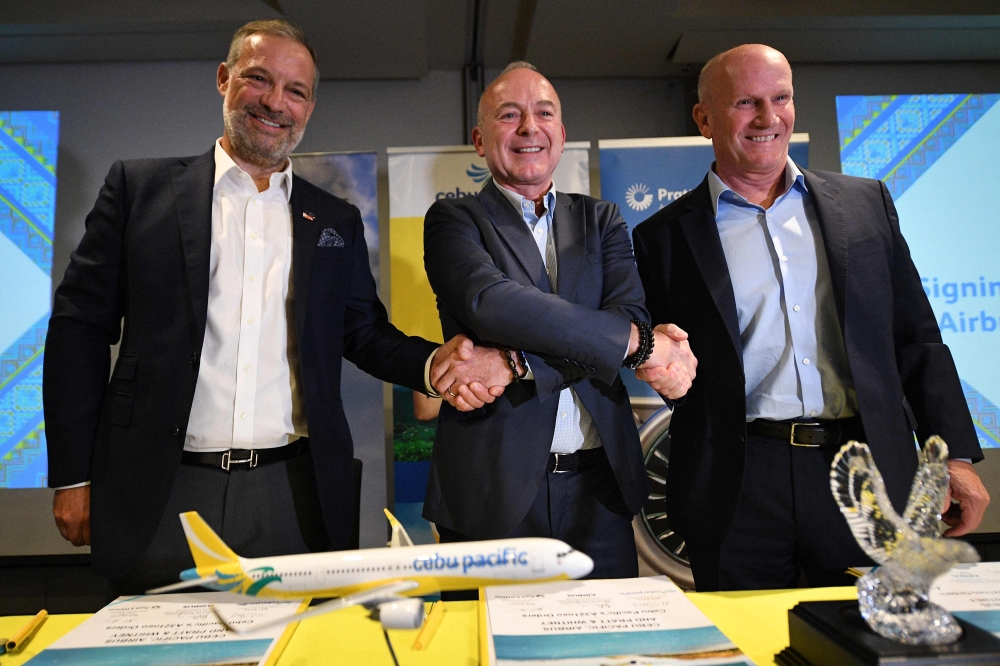 From L-R: Benoit de Saint-Exupery, Airbus executive vice president for commercial aircraft sales, Cebu Pacific chief executive Michael Szucs, and Pratt & Whitney president for commercial engines Rick Deurloo pose during a signing ceremony in Manila on October 2, 2024. Photo by Ted ALJIBE / AFP