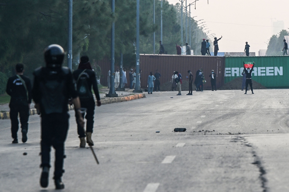 Supporters and activists of former Prime Minister Imran Khan's Pakistan Tehreek-e-Insaf (PTI) party, gather as they shout slogans during a protest in Islamabad on October 4, 2024. (Photo by Farooq Naeem / AFP)
