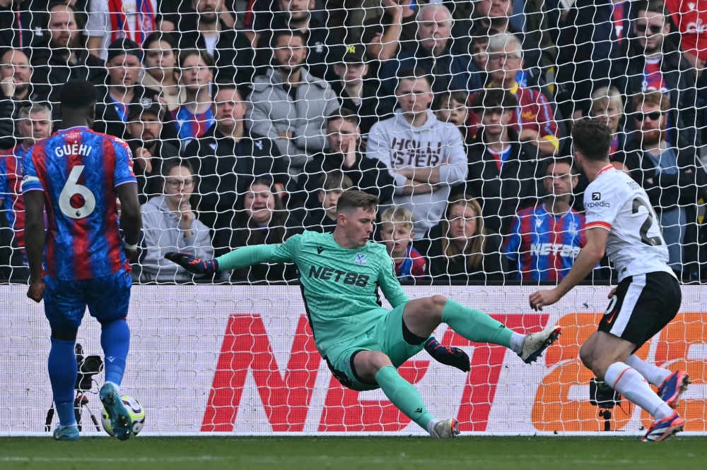 Liverpool's Portuguese striker #20 Diogo Jota (R) shoots past Crystal Palace's English goalkeeper #01 Dean Henderson (C) to score the opening goal of the English Premier League football match between Crystal Palace and Liverpool at Selhurst Park in south London on October 5, 2024. (Photo by Glyn KIRK / AFP)

