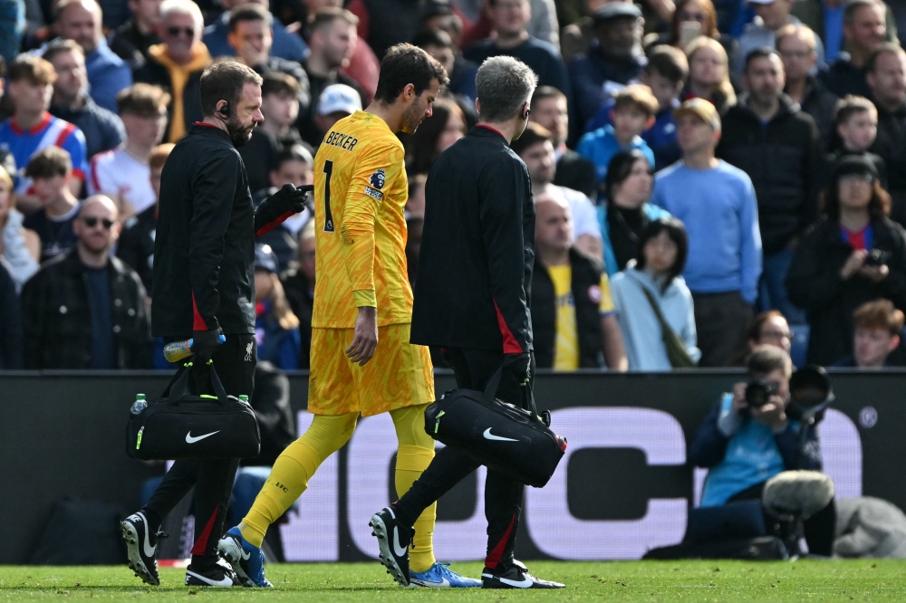 Liverpool's Brazilian goalkeeper #01 Alisson Becker leaves the game after picking up an injury during the English Premier League football match between Crystal Palace and Liverpool at Selhurst Park in south London on October 5, 2024. (Photo by Glyn KIRK / AFP)