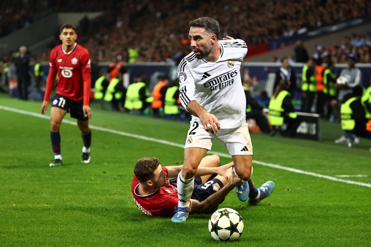Real Madrid's Spanish defender #02 Dani Carvajal (R) and Lille's Sweden’s defender #05 Gabriel Gudmundsson fight for the ball during the UEFA Champions League football match between Lille LOSC and Real Madrid at the Pierre Mauroy Stadium in Villeneuve-d'Ascq, northern France, on October 2, 2024. Photo by Sameer AL-DOUMY / AFP.
