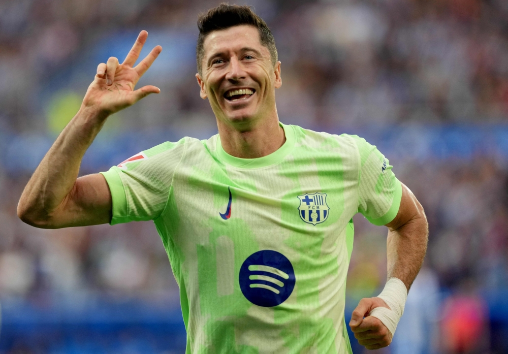 Barcelona's Polish forward #09 Robert Lewandowski celebrates after scoring a hat-trick during the Spanish league football match between Deportivo Alaves and FC Barcelona at the Mendizorroza stadium in Vitoria on October 6, 2024. (Photo by Cesar Manso / AFP)