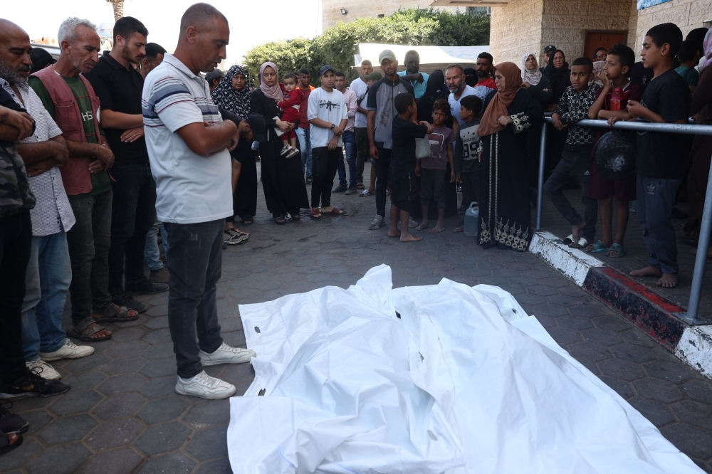 Palestinians pray over the bodies of relatives, killed in an Israeli strike on Al-Bureij refugee camp, during their funeral at the al-Aqsa Martyrs hospital in Deir al-Balah in the central Gaza Strip on October 13, 2024. (Photo by Eyad Baba / AFP)